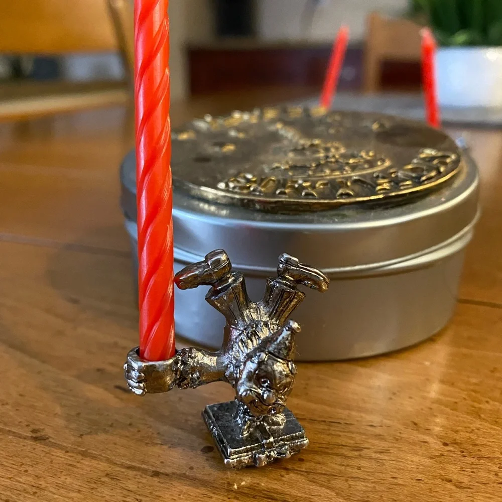 Set of animal candle holders stored in a metal tin.